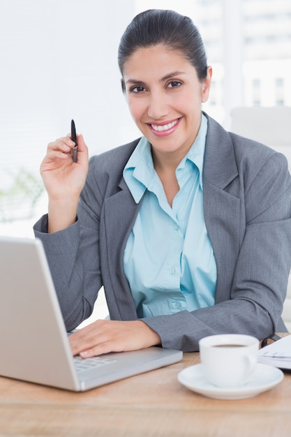 Sourire de femme d&#39;affaires à l&#39;aide de son ordinateur