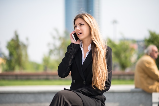 Sourire de femme d'affaires à l'aide de son téléphone portable