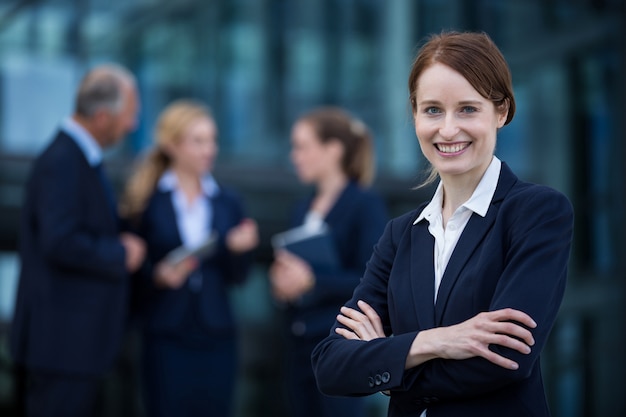 Sourire, femme affaires, debout, bras, traversé