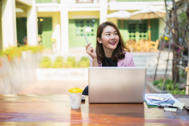 Sourire Femme d&#39;affaires travaillant au bureau avec des documents