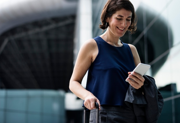 Sourire de femme d&#39;affaires en utilisant son téléphone