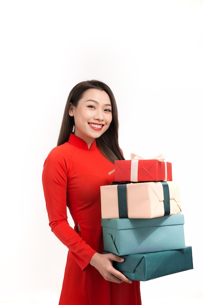 Sourire femme asiatique à ao dai tenant une boîte cadeau de nouvel an présente.