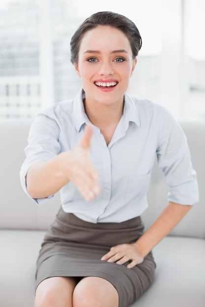 Sourire femme bien habillée offrant une poignée de main