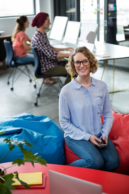 Sourire de femme dirigeant d'entreprise assis au bureau
