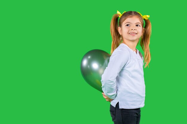 Sourire de femme enfant en bas âge avec des nattes cache un ballon