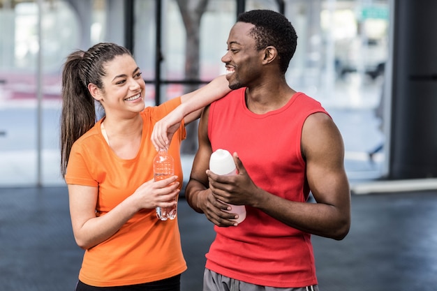 Sourire femme et homme après l&#39;effort au gymnase