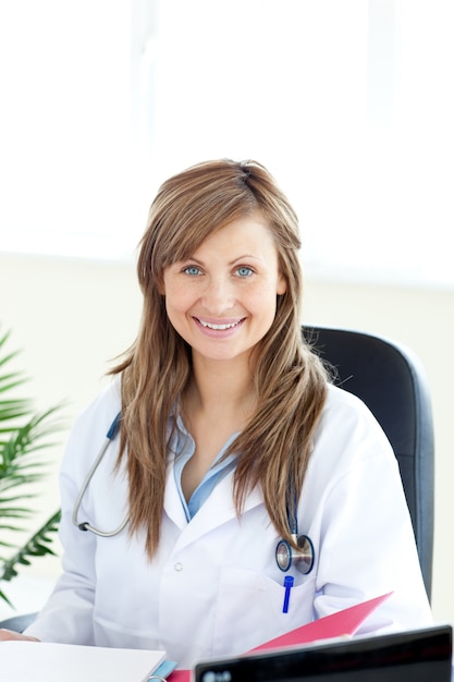 Sourire femme médecin en regardant la caméra