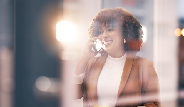 Sourire d'une femme noire et appel téléphonique d'affaires pour une conversation de communication et une connexion réseau Visage d'un entrepreneur heureux dans un immeuble de bureaux avec un smartphone tout en parlant au contact