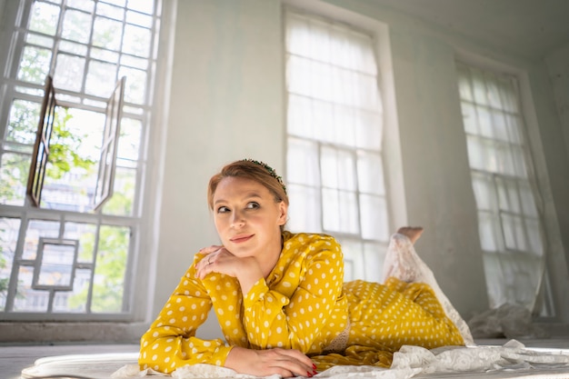 Photo sourire d'une femme rousse heureuse allongée sur le sol