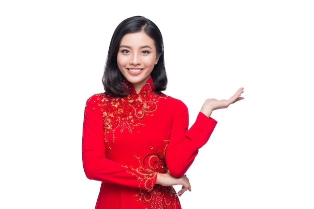 Sourire femme vietnamienne en robe traditionnelle Ao Dai et présenter sur fond blanc.