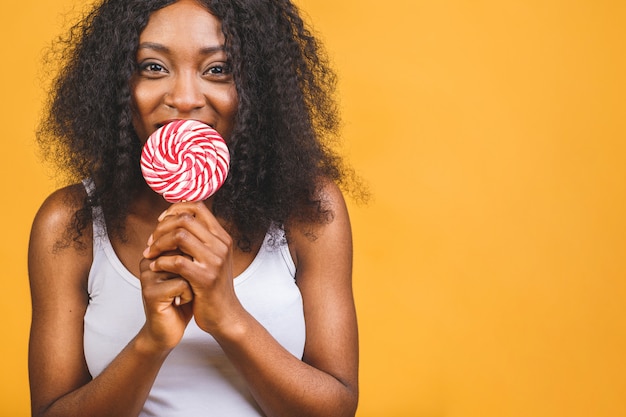 Sourire fille africaine américaine tenant une sucette de bonbons