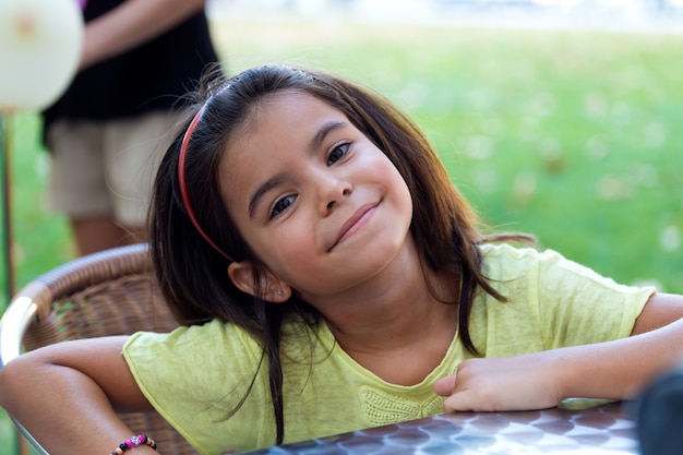 Sourire fille assise à table