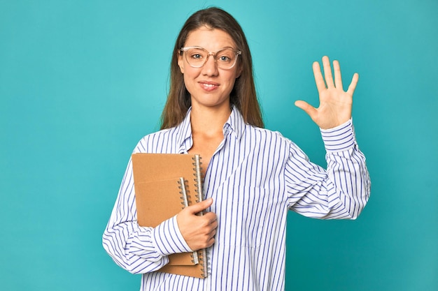 Sourire gai montrant le numéro cinq avec les doigts