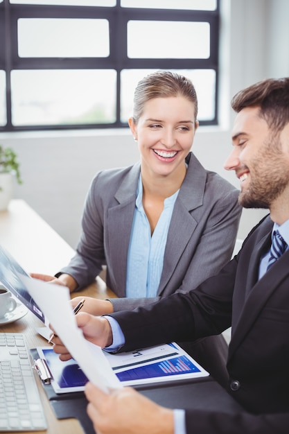 Sourire de gens d'affaires discutant de documents