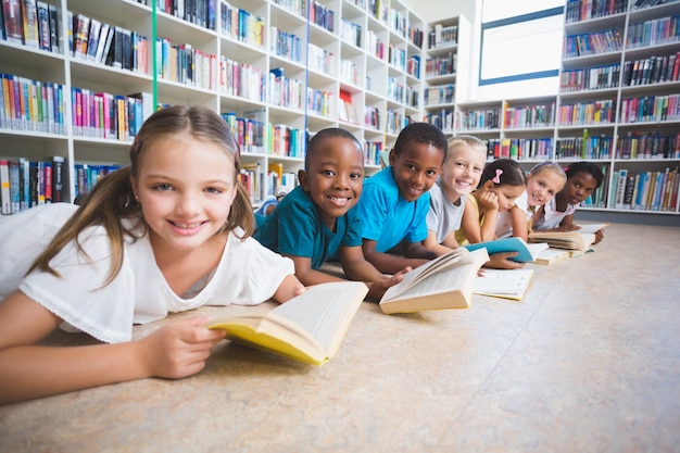 Sourire, gosses école, mensonge plancher, lecture livre, dans, bibliothèque