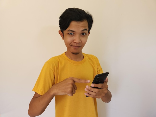 Sourire heureux face à un homme asiatique qui a trouvé une meilleure application dans son mobile