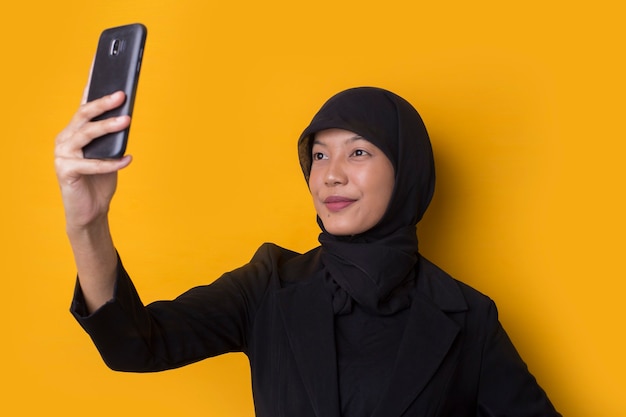 Sourire heureux femme d'affaires musulmane asiatique prenant un selfie