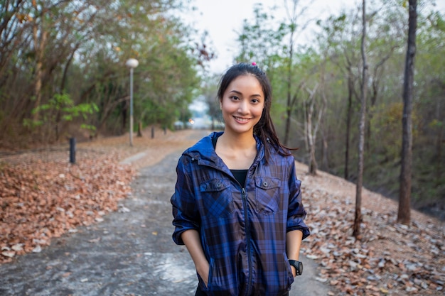 Sourire heureux femme asiatique fait du jogging dans le parc