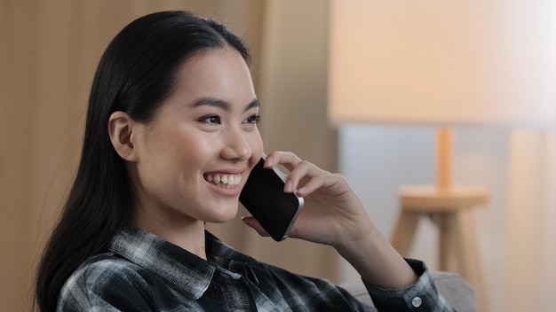 Sourire heureux femme asiatique portrait fille sourire parlant téléphone portable à la maison Gros plan dame coréenne