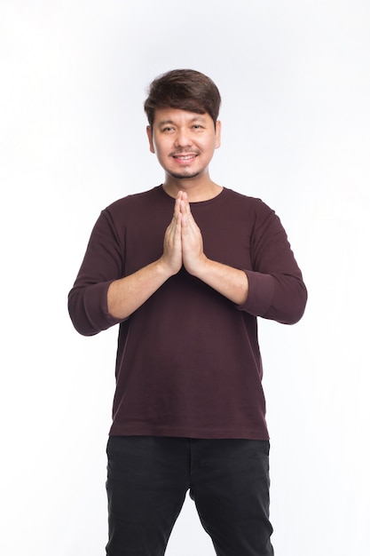 Sourire de l'homme asiatique et salutation par respect traditionnel thaïlandais, Sawatdee, isolé sur fond blanc