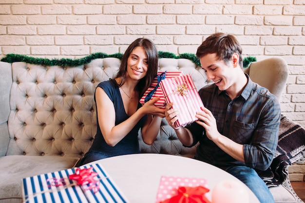 Sourire homme et femme devinant des cadeaux