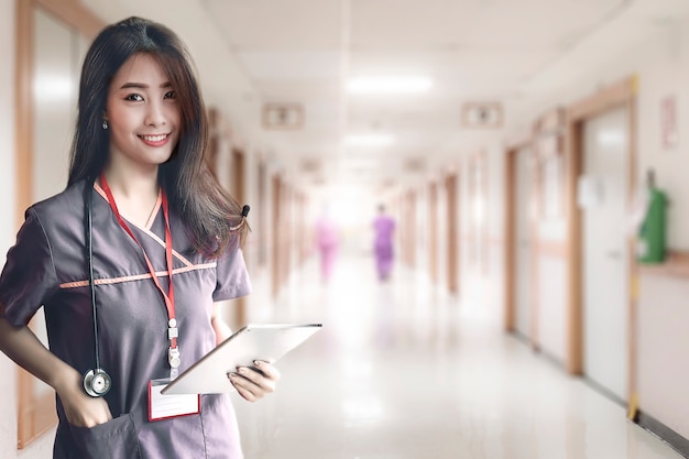 Sourire d'infirmière avec stéthoscope permanent à l'hôpital.