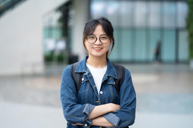 Sourire de jeune fille en regardant et en utilisant des écouteurs de téléphone portable