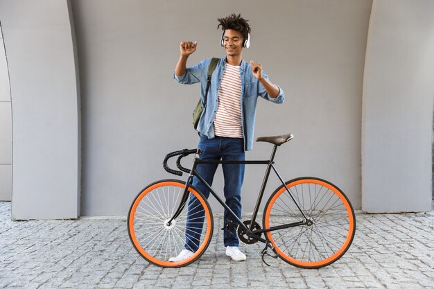 Sourire jeune homme à l'extérieur avec vélo