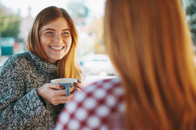 Sourire de jeunes filles buvant du café