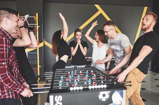 Sourire de jeunes jouant au baby-foot pendant les vacances.