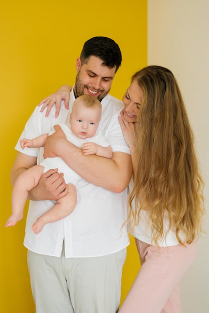 Sourire de jeunes parents heureux maman papa avec bébé bébé fils regardant la caméra Journée de la famille le concept de l'enfance parentale