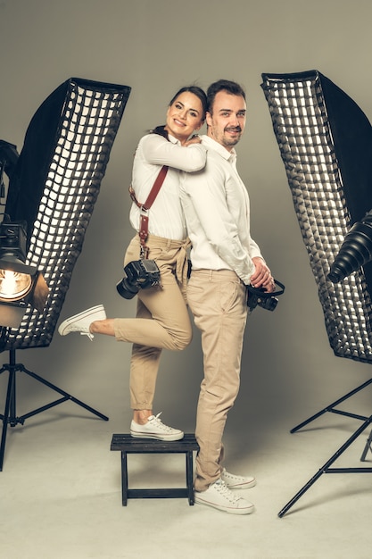 Sourire de jeunes photographes professionnels posant en studio