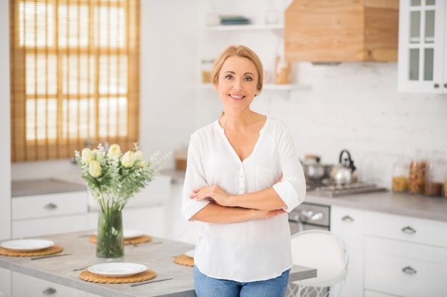 Sourire jolie femme au foyer debout dans la cuisine