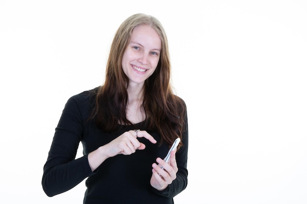 Sourire jolie femme mignonne avec de longs cheveux blonds tenant un téléphone portable smartphone sur fond blanc