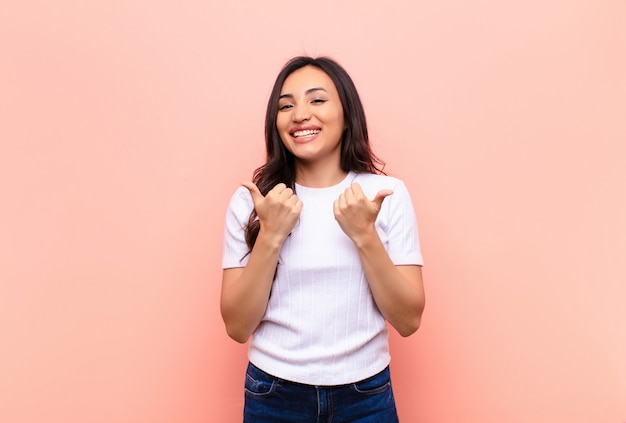 sourire joyeusement et avoir l'air heureux, se sentir insouciant et positif avec les deux pouces levés