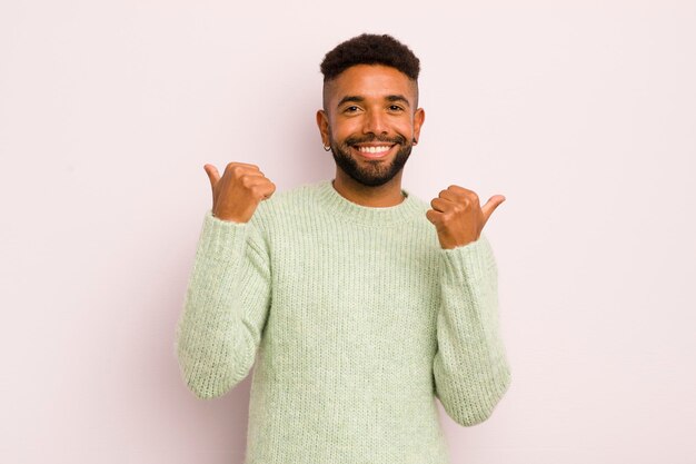 Sourire joyeusement et avoir l'air heureux, se sentir insouciant et positif avec les deux pouces vers le haut