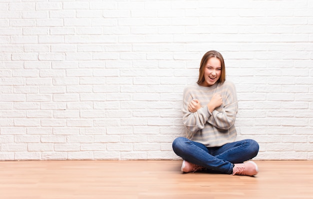 sourire joyeusement et célébrer, les poings serrés et les bras croisés, se sentir heureux et positif