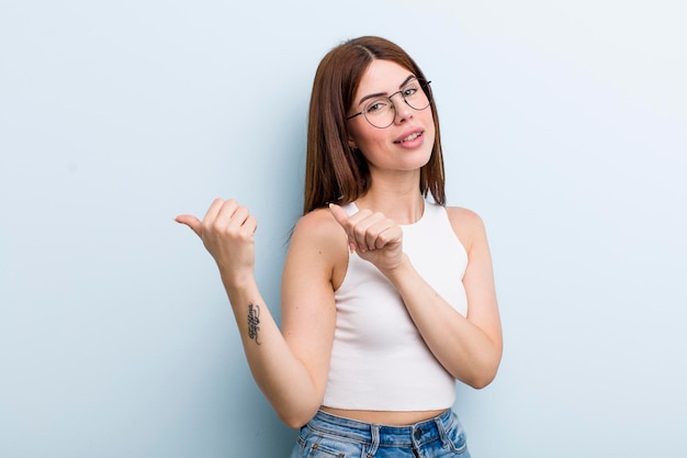 Sourire joyeusement et avec désinvolture pointant vers l'espace de copie sur le côté se sentant heureux et satisfait