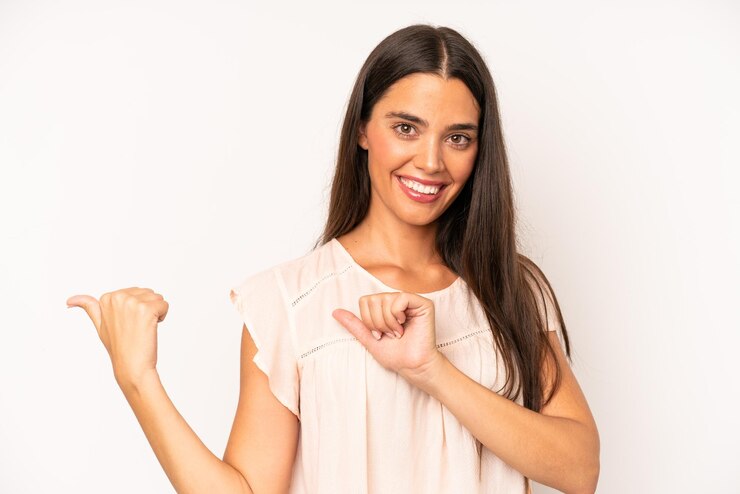 Photo sourire joyeusement et avec désinvolture pointant vers l'espace de copie sur le côté se sentant heureux et satisfait