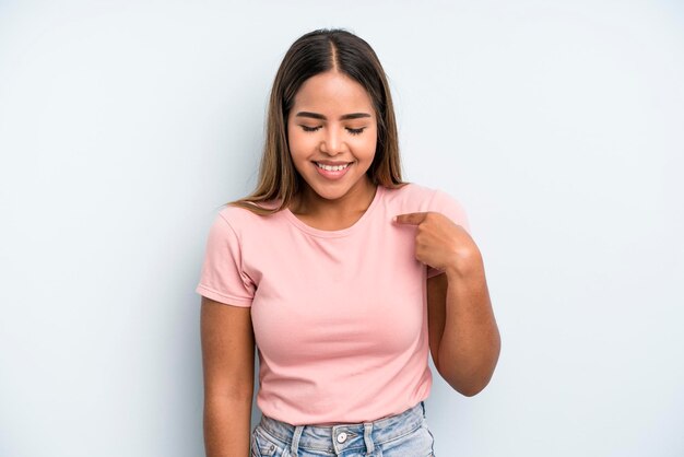 Sourire joyeusement et avec désinvolture en regardant vers le bas et en pointant vers la poitrine