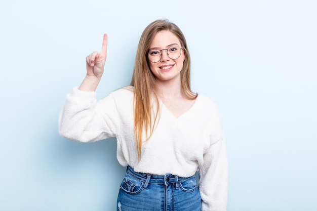 Sourire joyeusement et heureusement vers le haut avec une main pour copier l'espace