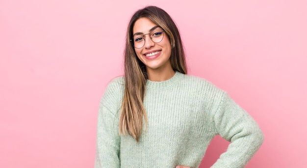 Sourire joyeusement avec une main sur la hanche et une attitude positive, fière et amicale