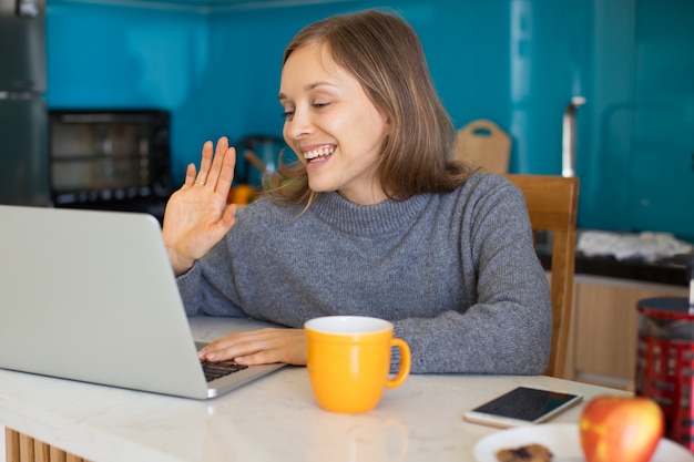 Photo sourire lady vidéo appelant sur l'ordinateur dans la cuisine