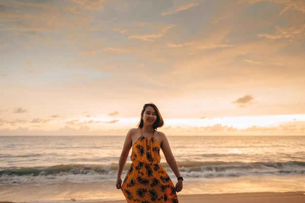 Photo sourire liberté et bonheur femme asiatique sur la plage elle profite de la nature sereine de l'océan pendant les vacances de voyage vacances en plein air beauté asiatique heure d'été