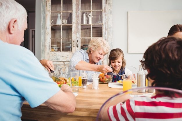 Sourire mamie et petite-fille assise à la table à manger