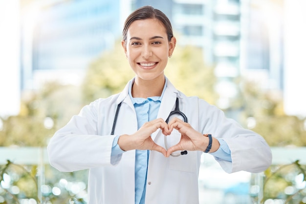 Sourire médecin avec signe de coeur geste des mains dans une clinique de santé moderne ou un hôpital Heureux positif et bien-être jeune femme travailleur de la santé ou médecin avec soutien symbole d'amour et de soins