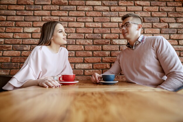 Sourire, mignon, couple, habillé, élégant, bavarder, et, boire café, dans, cafétéria