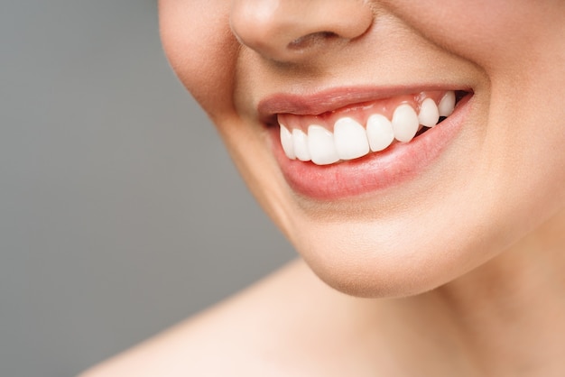 Le sourire parfait des dents saines d'une jeune femme blanchissant les dents de l'image du patient de la clinique dentaire symbolise