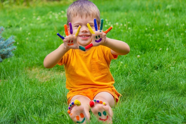 un sourire peint avec des peintures sur les bras et les jambes de l'enfant Focus sélectif