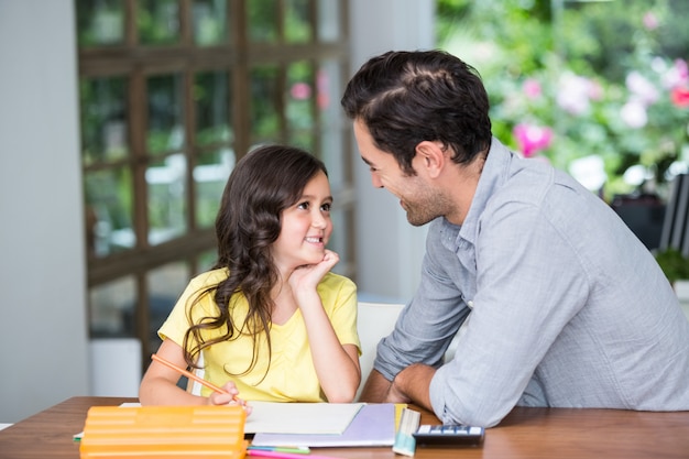 Sourire père et fille assis au bureau